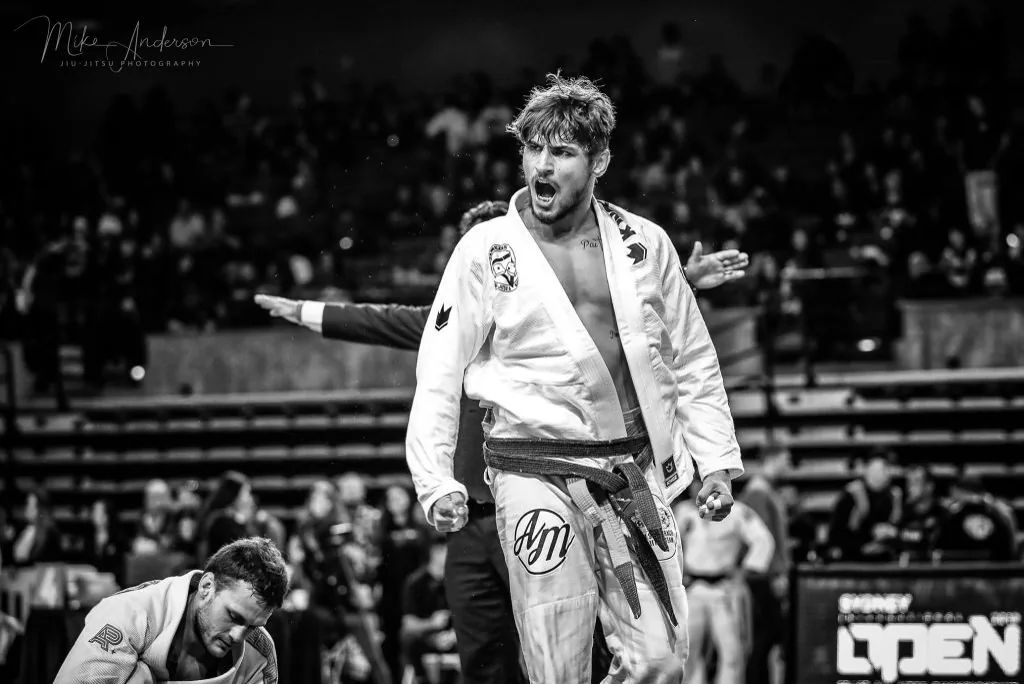 Black-and-white photo of Alex celebrating a win at a Jiu-Jitsu tournament