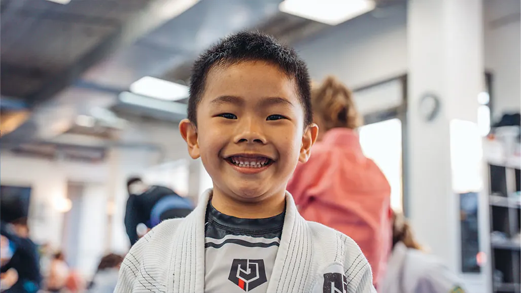 A smiling young student in a white gi