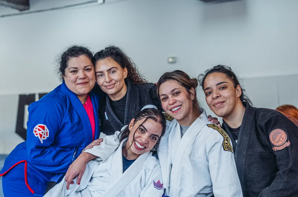 Members of the women’s class smiling together on the mat