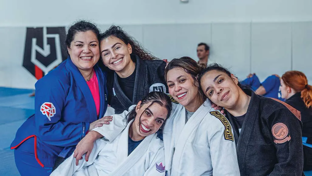 Women’s class members hugging and smiling after training